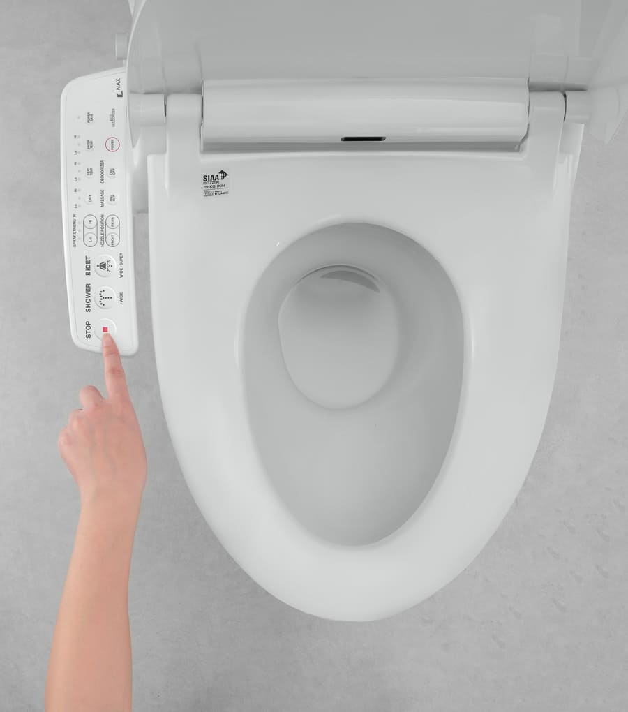Bàn cầu cao cấp lắp đặt nắp rửa điện tử thông minh tích hợp bảng điều khiển nút nhấn bên hông và vòi rửa tự động.
